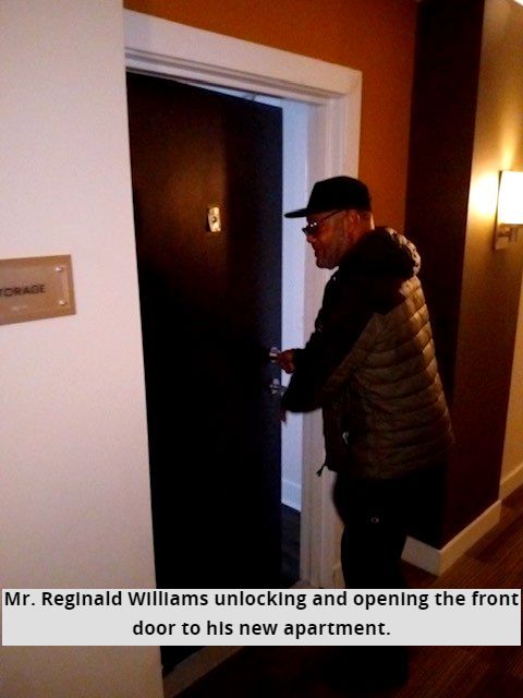 Mr. Reginald Williams unlocking and opening the front door to his new apartment. 