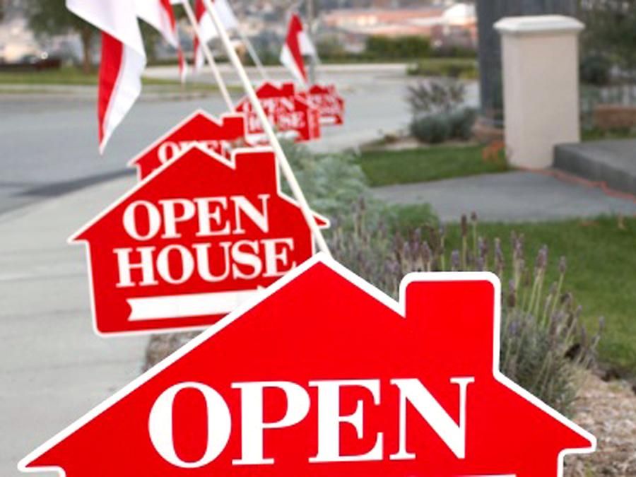 Red signs in the shape of houses that say "open house" lining a sidewalk