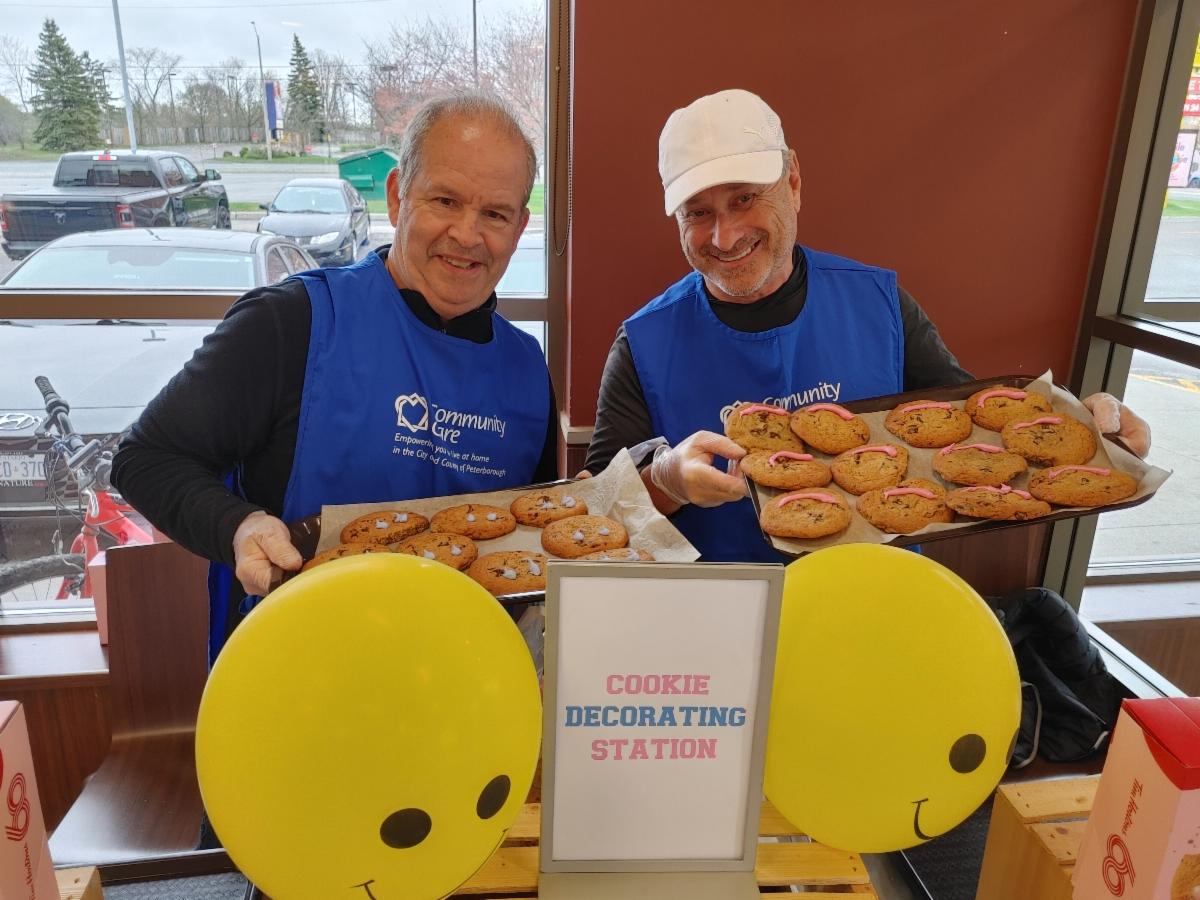 Volunteers Kevin and Paul icing Smile Cookies