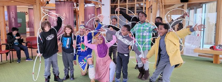 A photo of a Indigenous-Immigrants Heritage learning event, where newcomer youth learned about Indigenous traditional dances during an excursion to Wanuskewin Heritage Park.