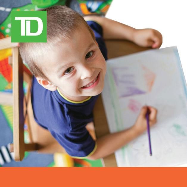 A photo of a kid painting, looking up and smiling.