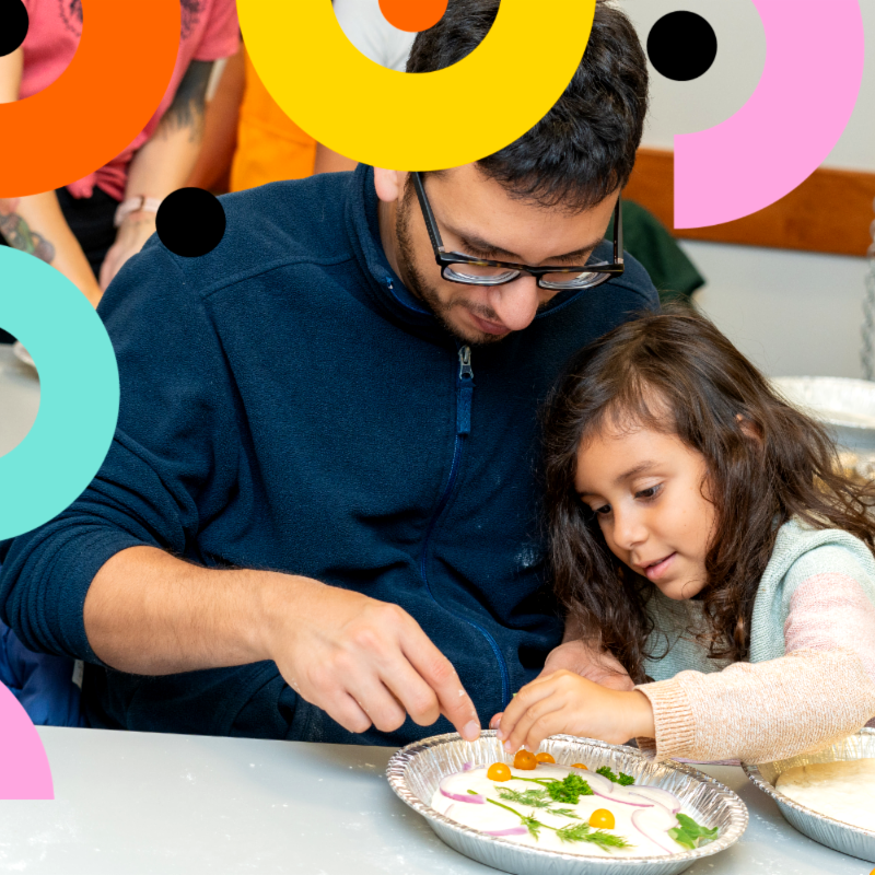 An adult and a kid decorating bannock at the "Baking Bannock with Jodi Robson" Culture Days event.