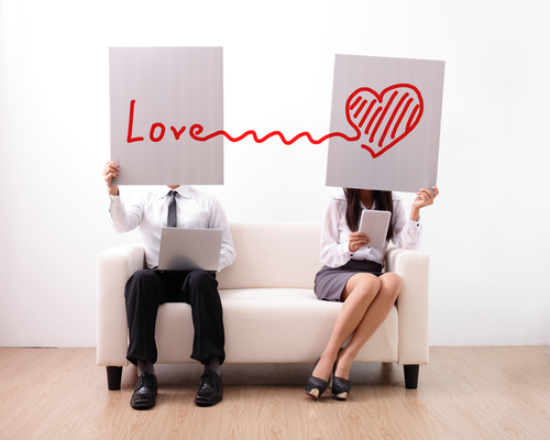 Find ture love on internet - man and woman using computer and digital tablet on sofa