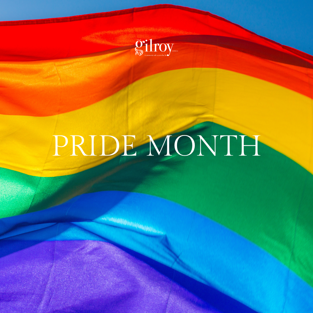 rainbow flag flying in the background with Pride Month message