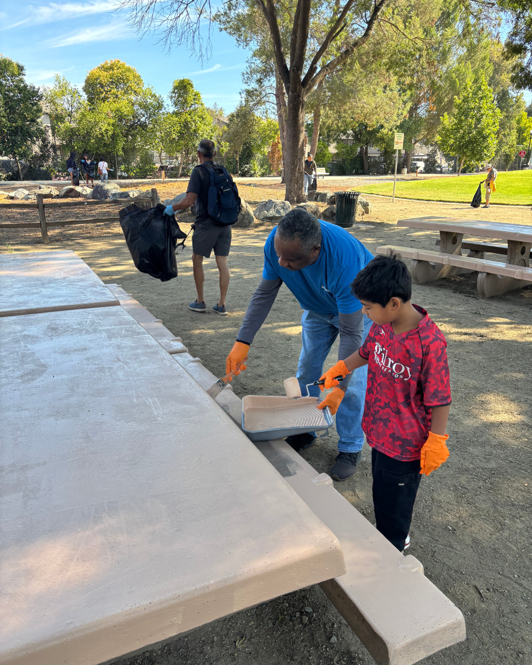 volunteers painting a picnic table at San Ysidro Park