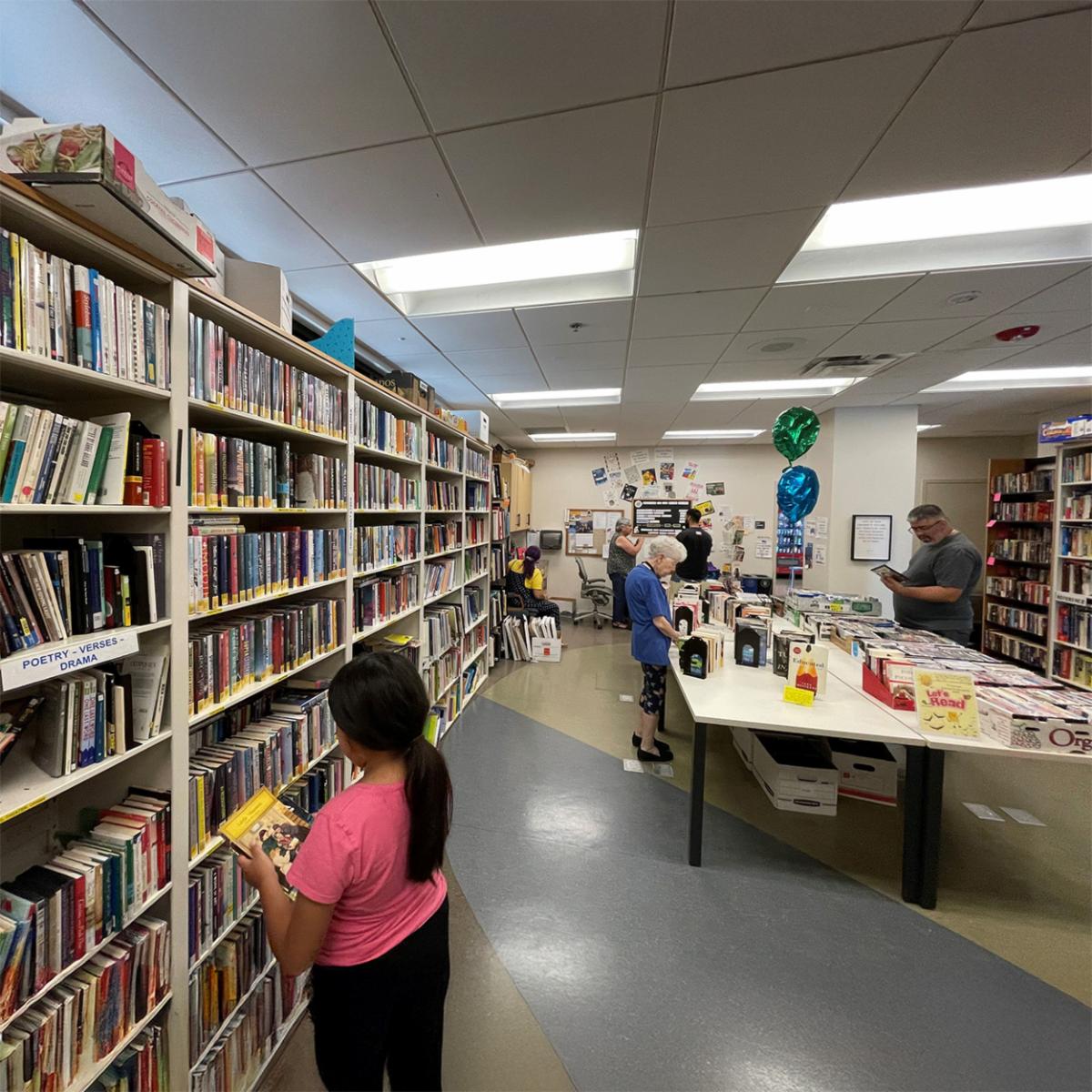 book shelves in the back and people reading books