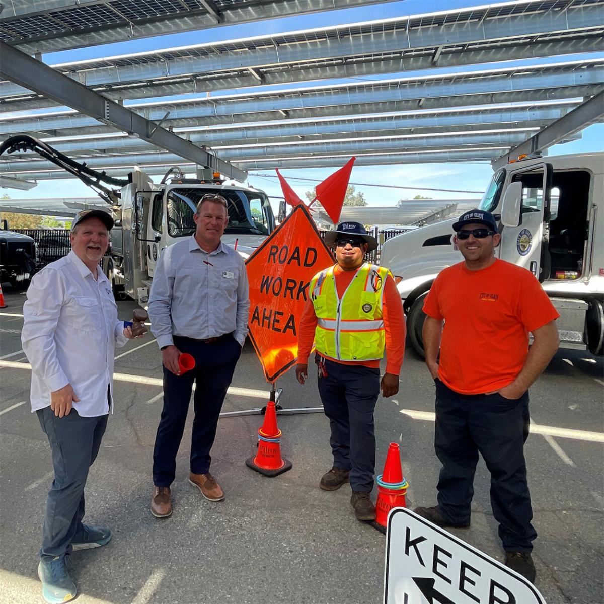 City of Gilroy Public Works Team members in front of a road work ahead sign