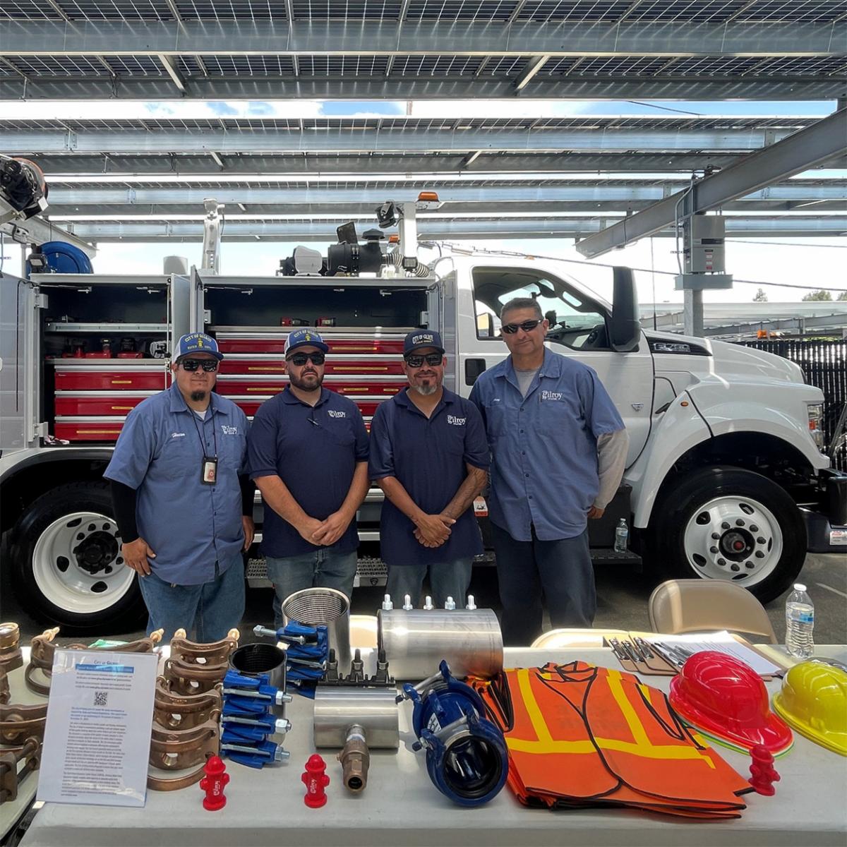 Public Works team members in front of a public works truck with a table of work items out front