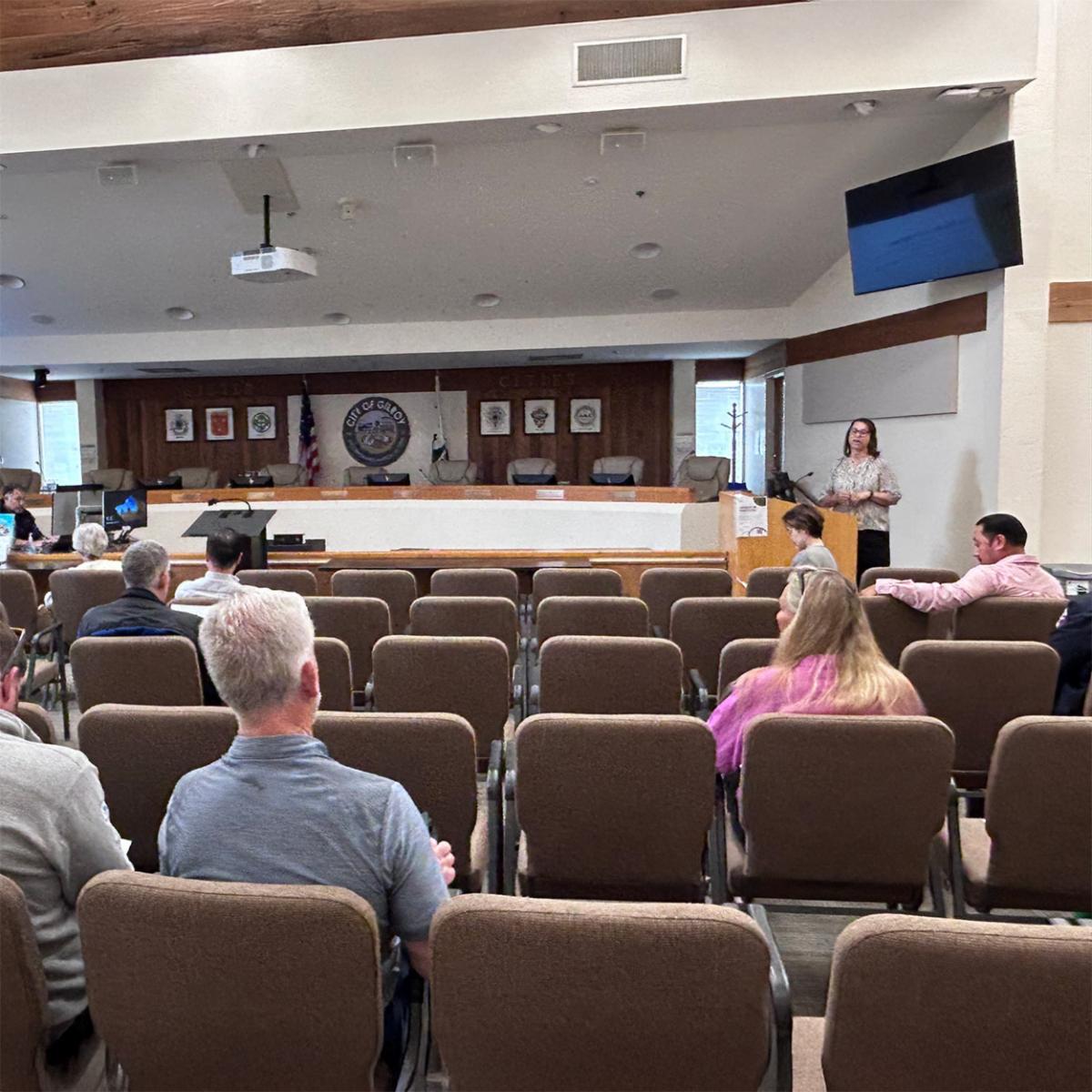 city staff presenting by a podium at council chambers