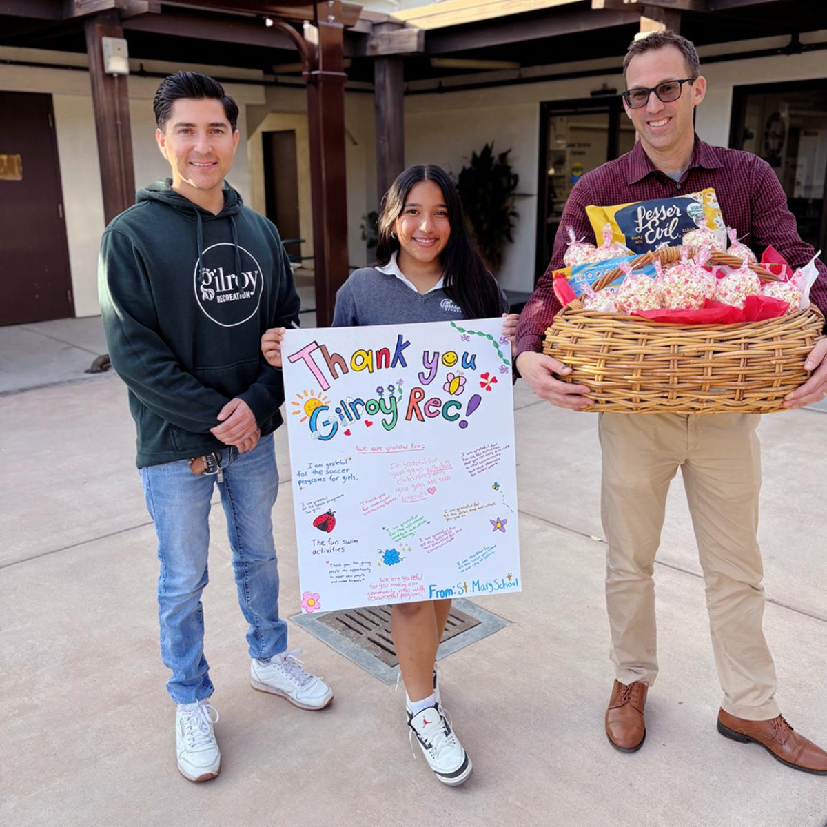 Gilroy Recreation Staff holding card and gift basket