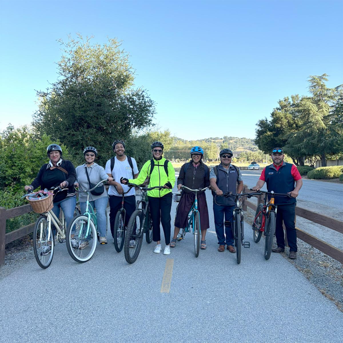 Seven bicyclists posing with their bikes on the Gilroy levee