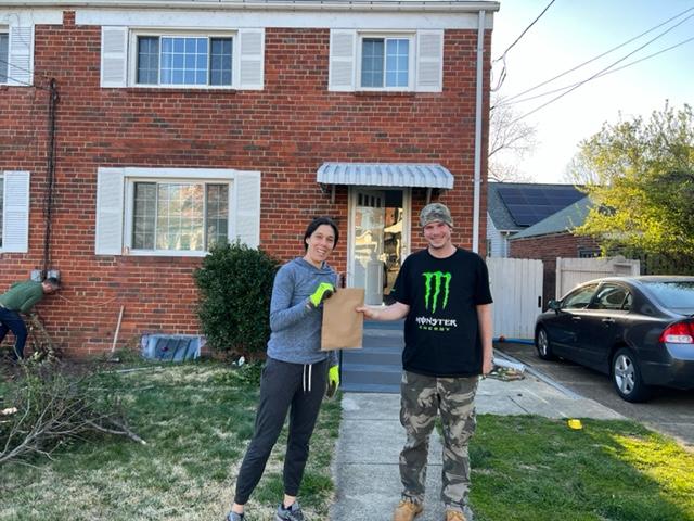 Two volunteers holding stakes to mark the spot for tree planting in Penrose