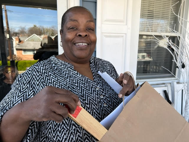 Smiling volunteering holding a stake to make the spot to plant trees