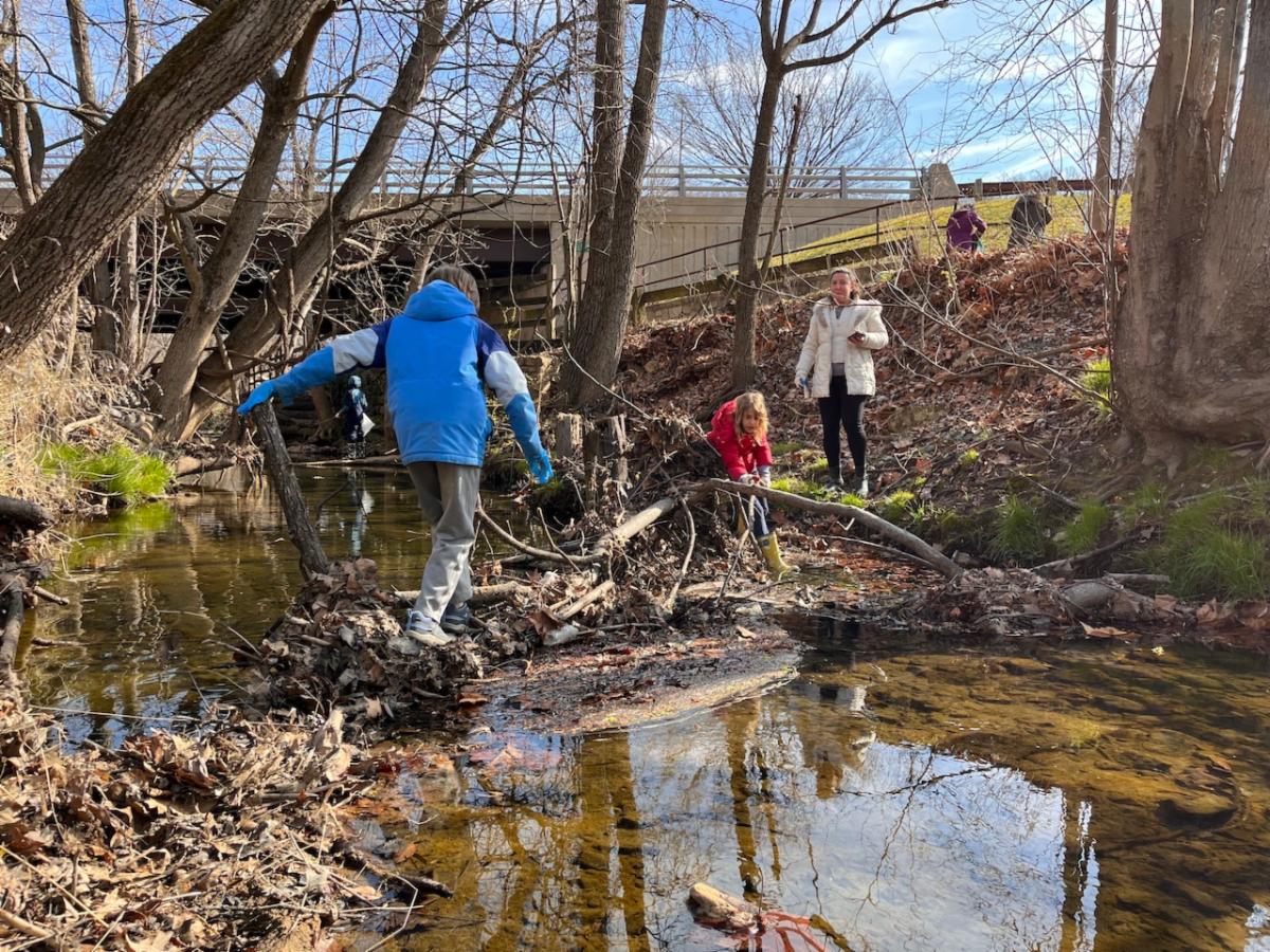 Kidsgiving volunteers cleaning up a stream in Arlington March 2023