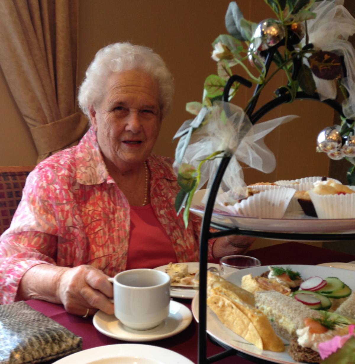 A smiling woman having afternoon tea 