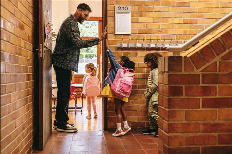 teacher welcoming young students to class