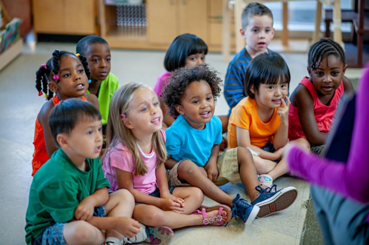 young students sitting on the floor