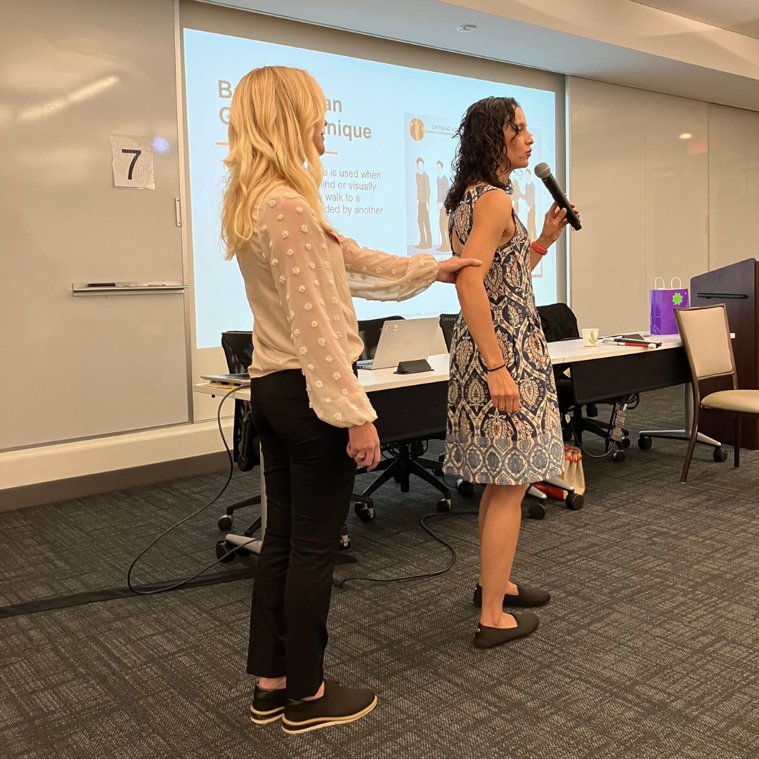 Orientation and Mobility Specialists Kara Peters and Karin Barrows demonstrate the human guide technique