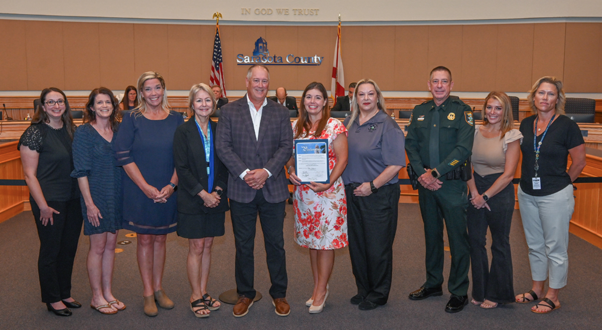 Photo of people standing in commission chambers for the International Grant Professionals Day proclamation. 