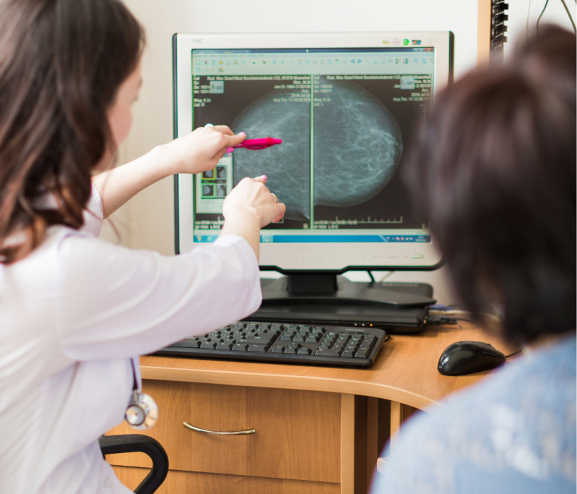 healthcare provider examining a breast scan image on a screen.