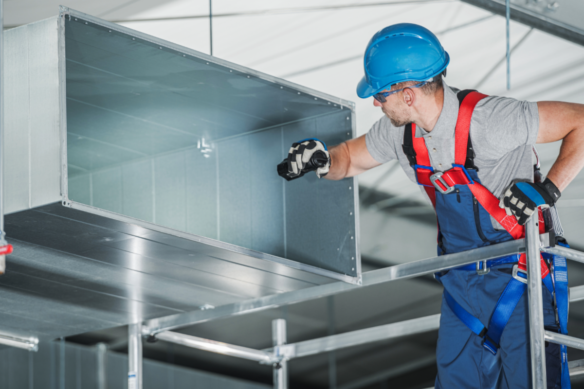 A person replacing a HVAC unit in a building