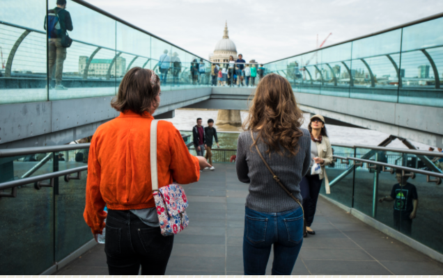 Two people walking on a bridge