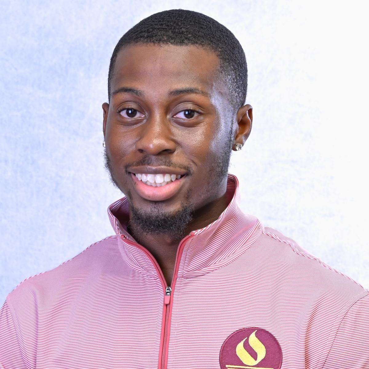 Ibe smiling wearing red STAC sweatshirt