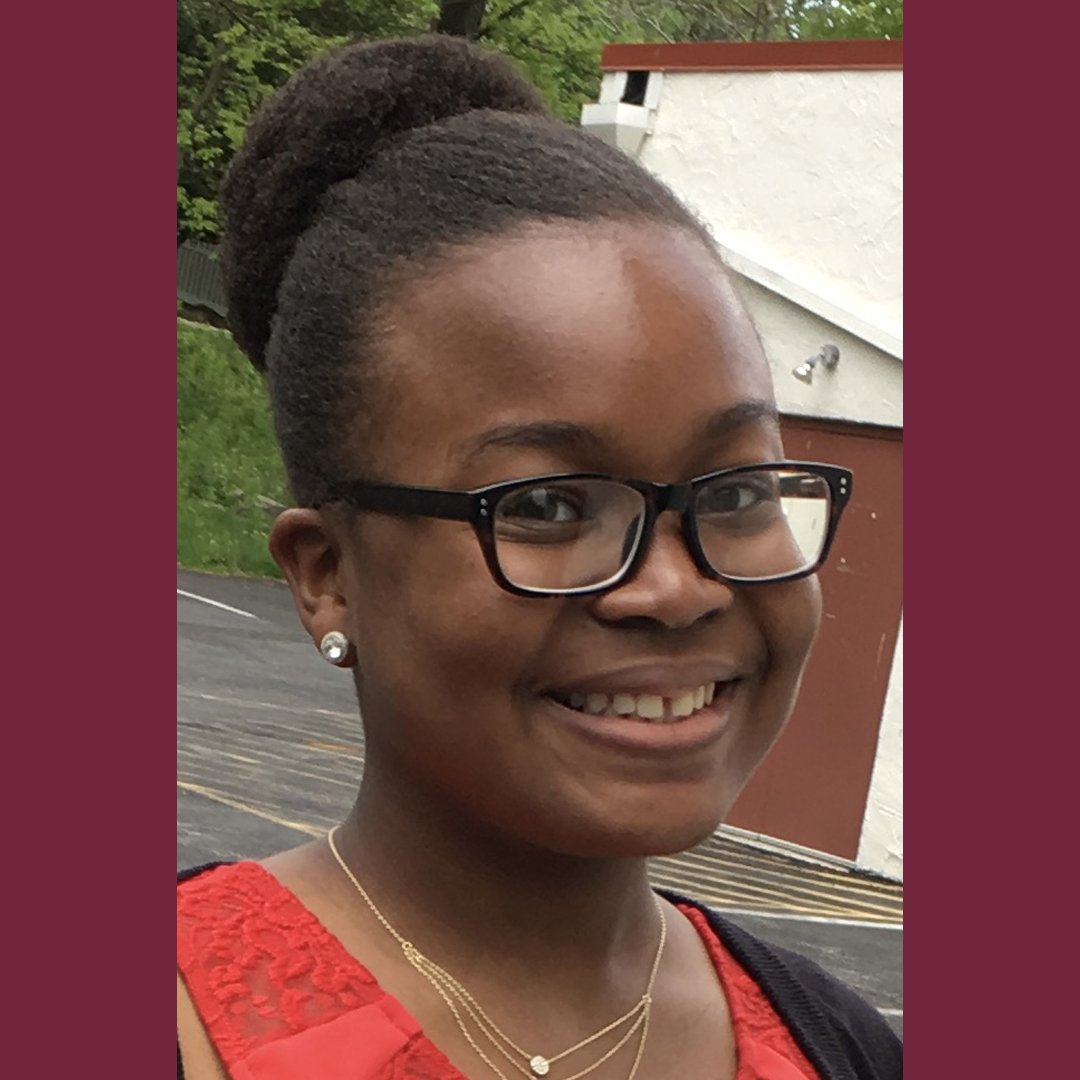 Layla smiling wearing glasses and red shirt