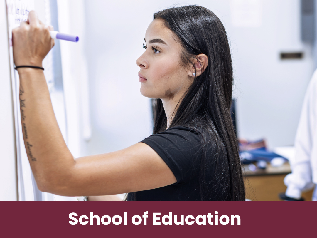 School of Education student writing on white board