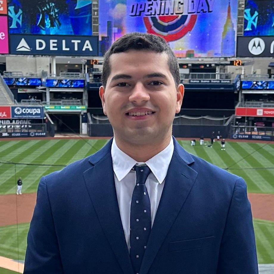 Matthew Quinones smiling wearing a suit with Yankee Stadium in background
