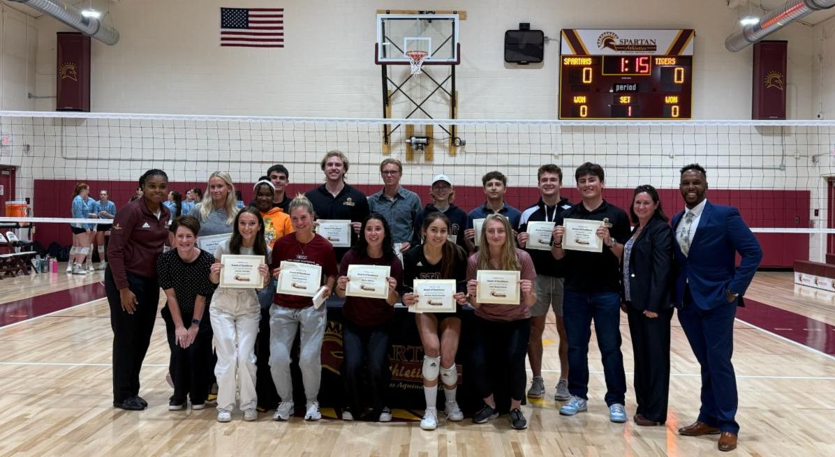 group of students with administration holding certificates in gym and smiling
