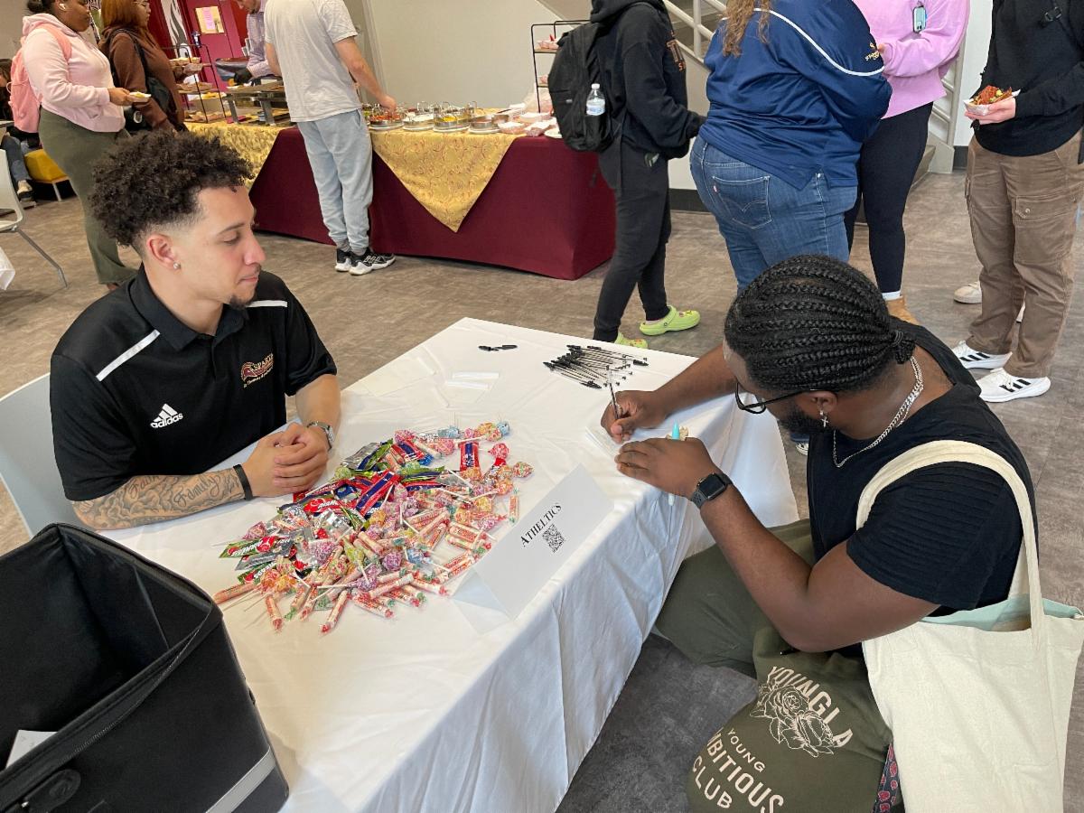 Students at table with candy and writing