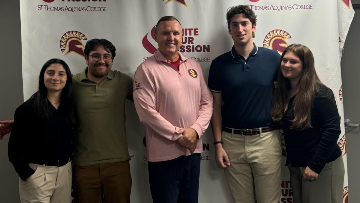 four members of panel and president daly smiling for photo