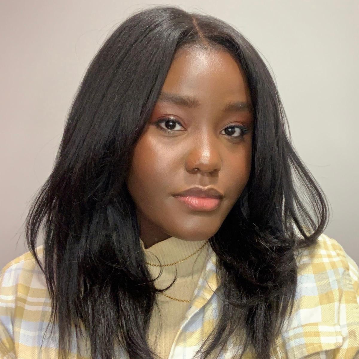 Rachelle smiling wearing hair down and yellow and white sweater