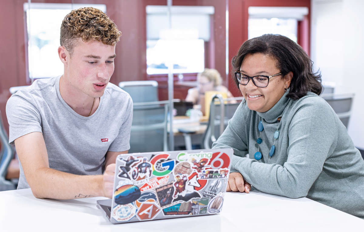Student with employee in career center on computer