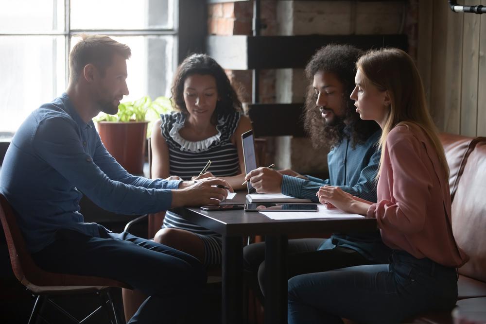 Four students seated at table studying