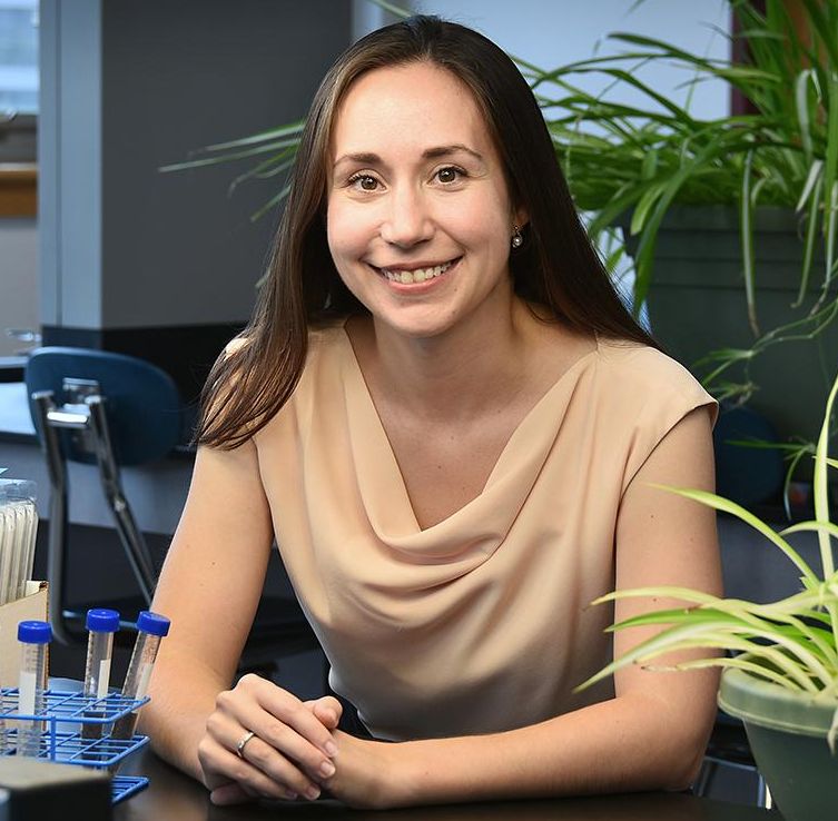 Bianca smiling in lab room with plants on right side