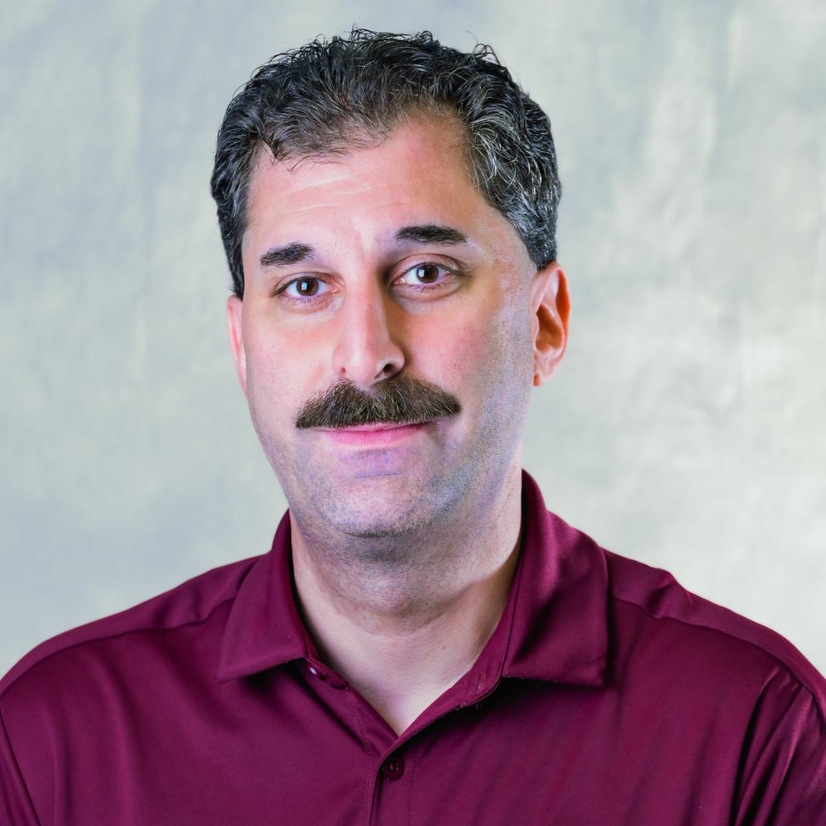 Brad smiling wearing maroon shirt