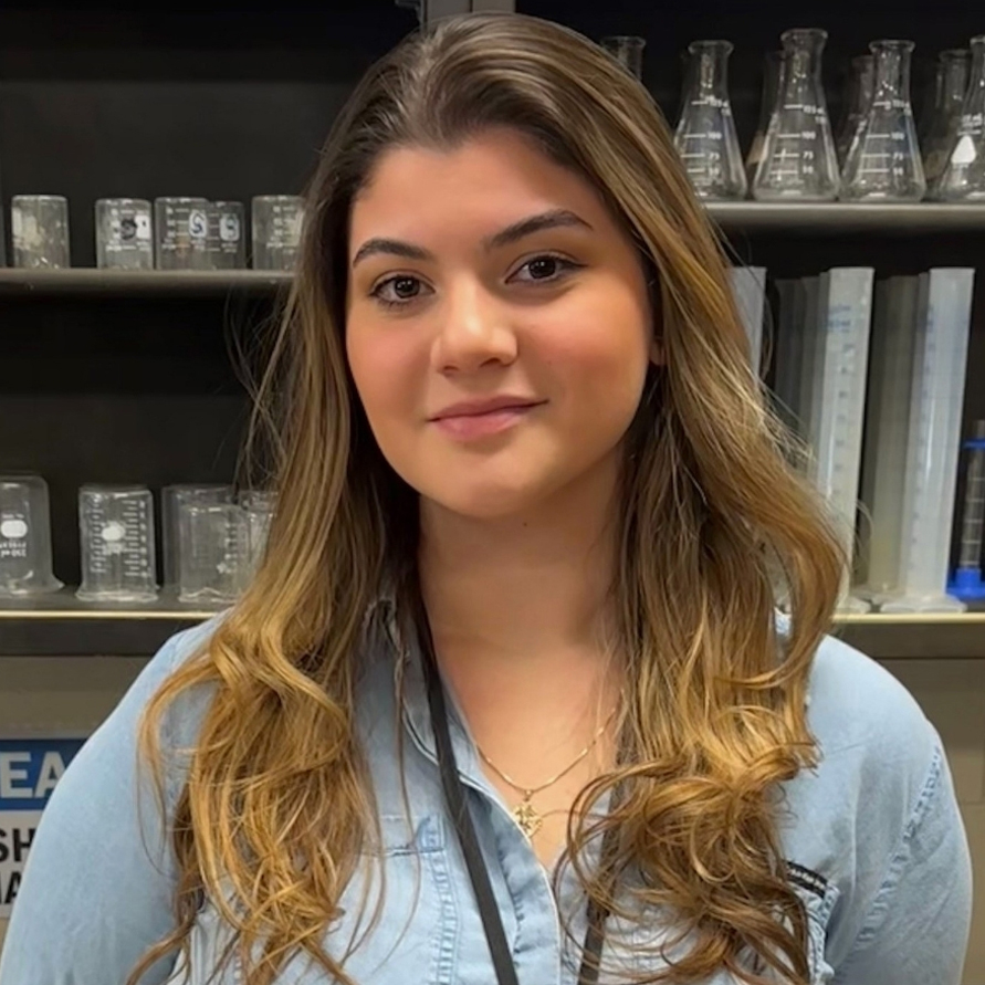 Madison smiling wearing jean jacket with high school lab cabinet in background