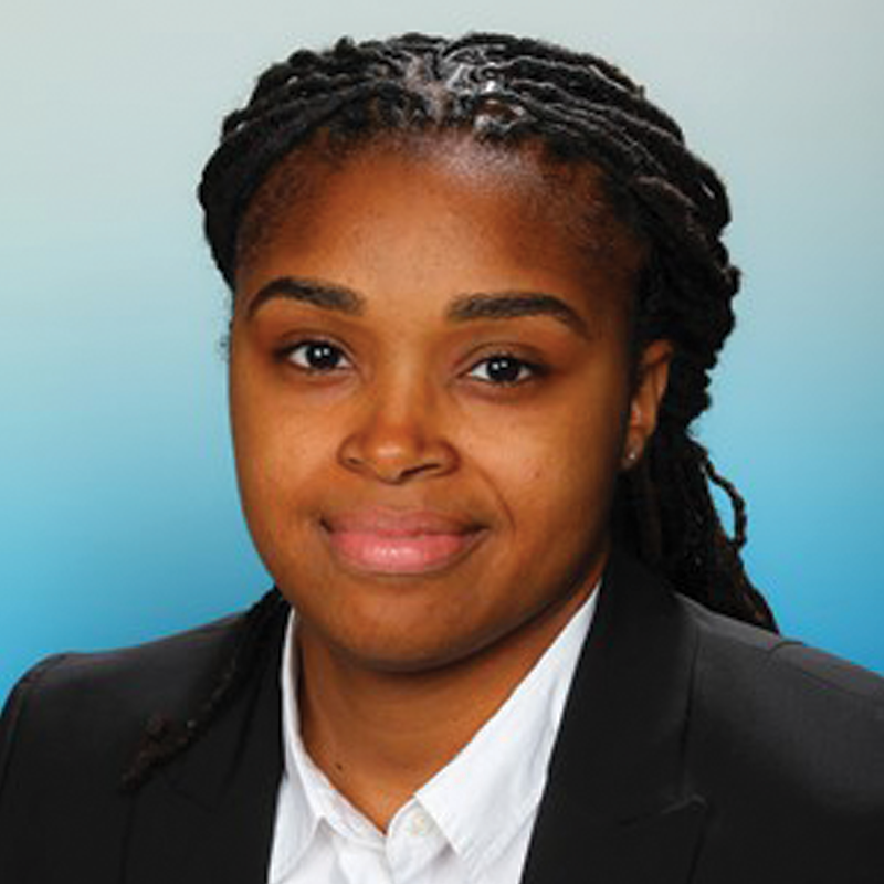 Rayven smiling wearing suit jacket with blue background