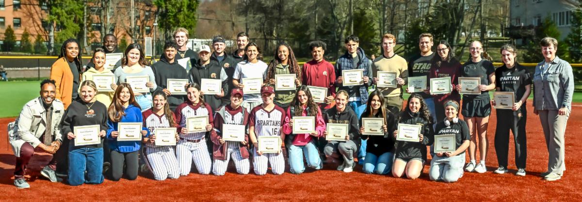 Athletics administration and student athletes posing on field outside for group photo