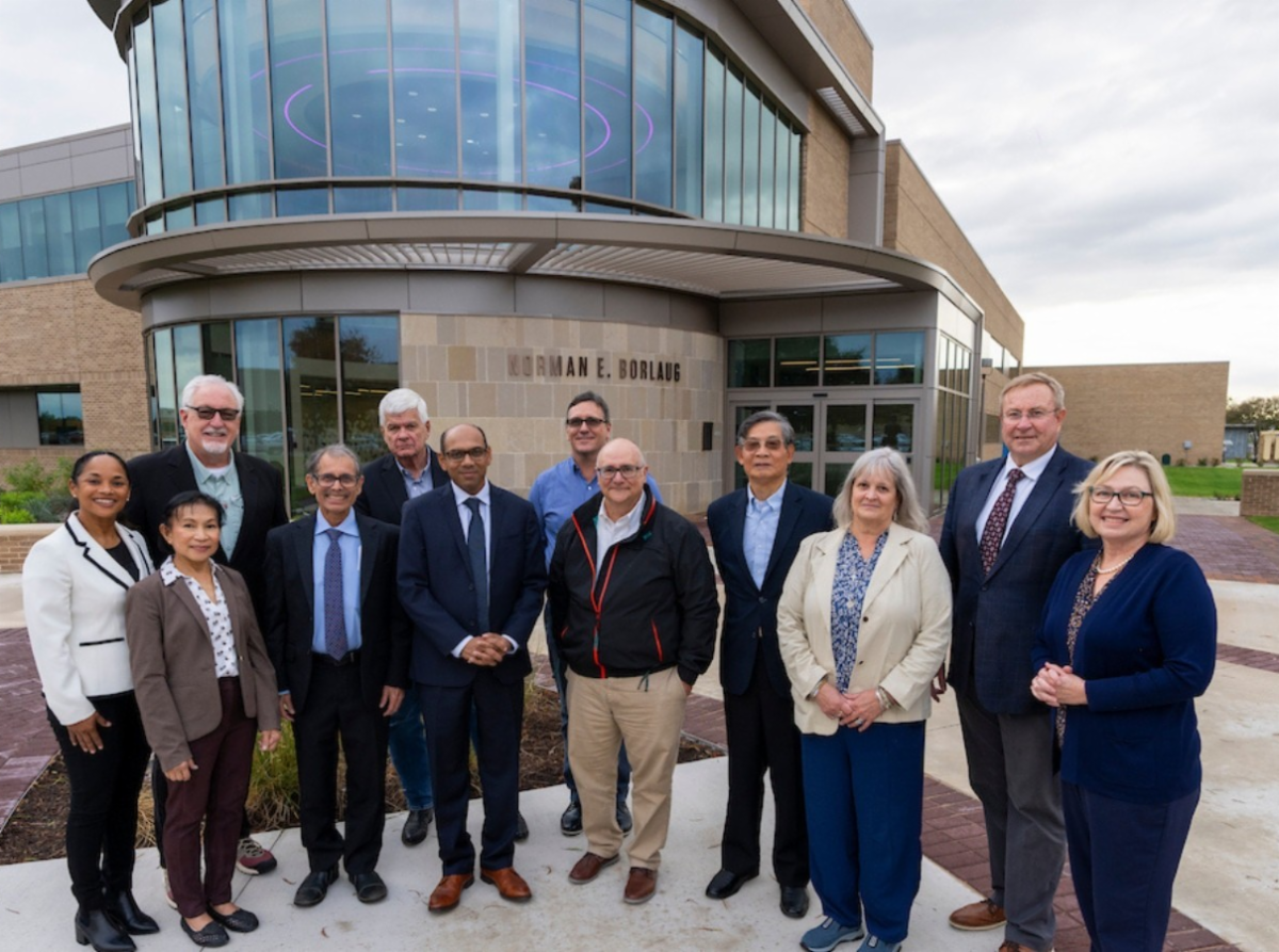 Group of people in suits standing in front of a modern building