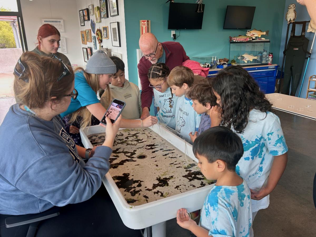 kids and parents collecting water sample