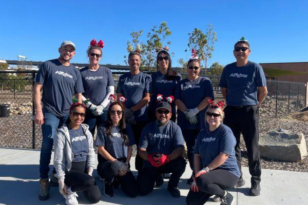 group photo of Air Communities employee while volunteering with Santa hats at Grant Park