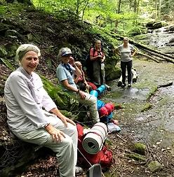 a group of people rest alongside a hiking trail