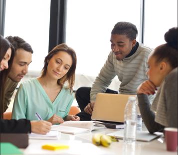 group of college students around a table studying