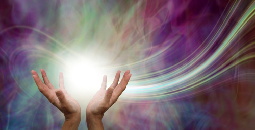 Stunning Healing Energy phenomenon  - female hands reaching up into a ball of white  energy with a laser trail and pink green ethereal energy field  background 