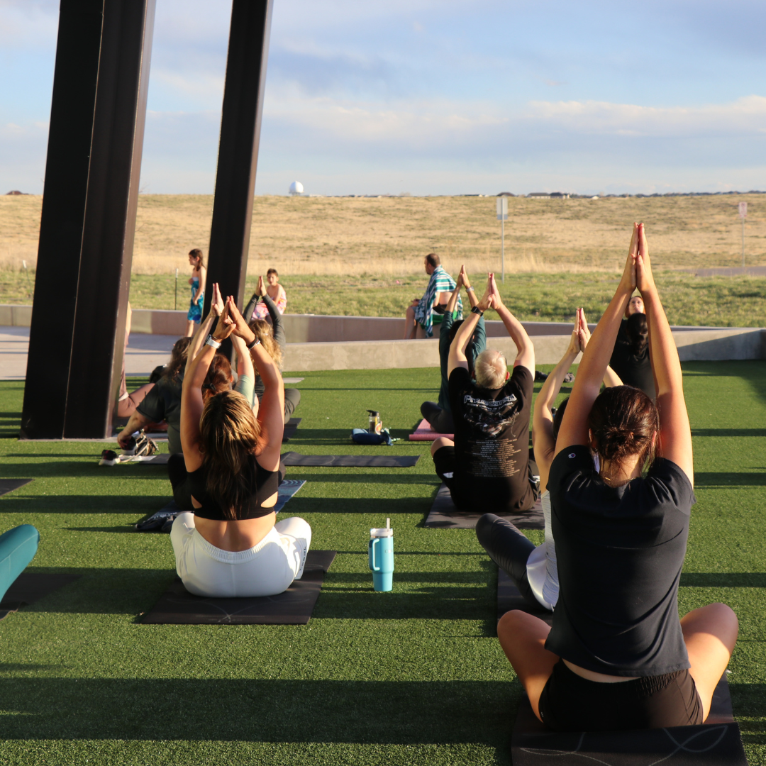 People doing sunset yoga on the turf at Southeast Recreation Center and Fieldhouse