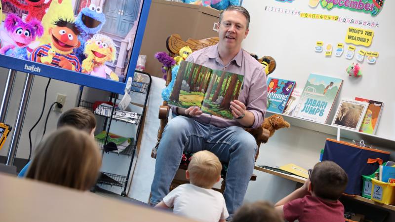 a volunteer reads to children at Lakeview Elementary School