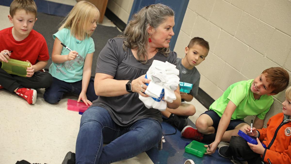 Justin first-grade teacher Susan Logan shows students a group of socks to sort.
